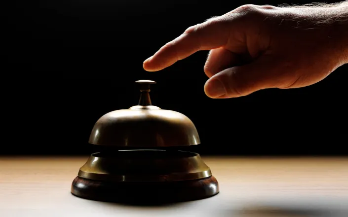 Hand ringing a concierge service bell