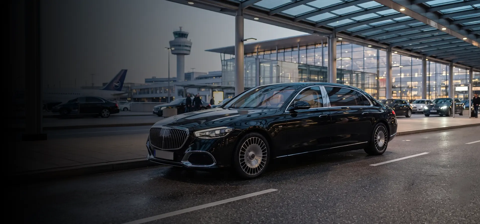 Chauffeur-driven Mercedes waiting at an airport terminal